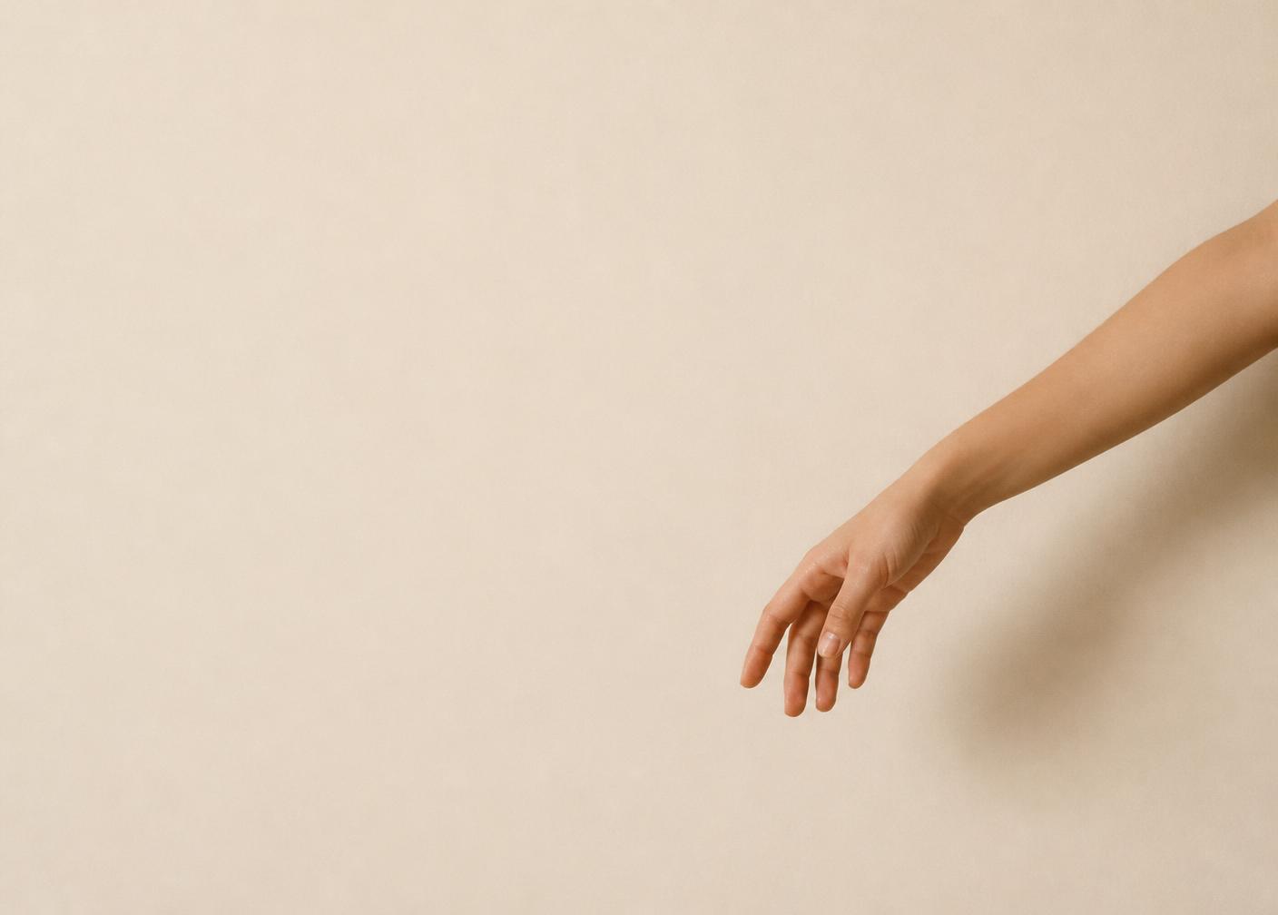 Détail éditorial d'un bras à la peau lisse sur fond ivoire